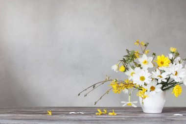 bahar beyaz ve sarı çiçekler arka planda eski duvarda