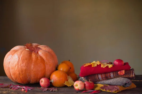 木製のテーブルの上に秋の葉を持つオレンジ色のカボチャ — ストック写真