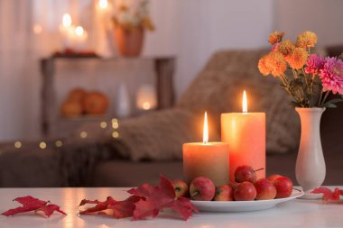 Evde yanan mumlarla sonbahar süslemeleri.