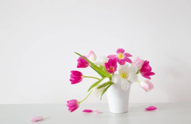 Beyaz vazoda beyaz ve pembe laleler arka plan duvarında