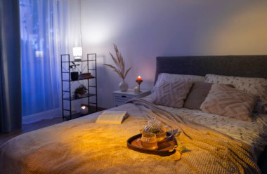 Sonbahar süslemeleriyle rahat bir yatakta bir fincan çay.