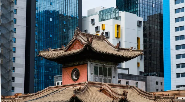 以摩天大楼为背景的城市中心古蒙古修道院屋顶 — 图库照片