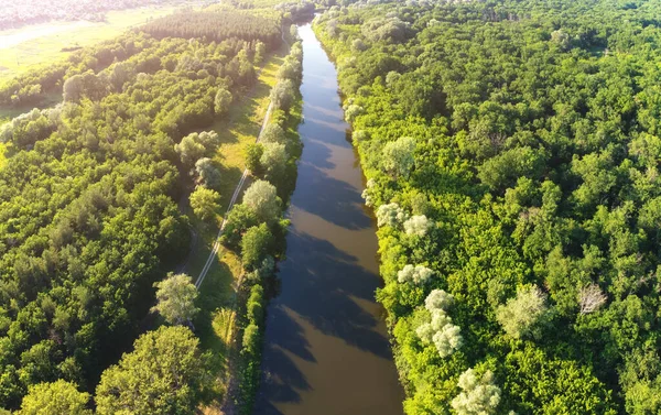 Straight line of river in green forest. Aerial view scenery.