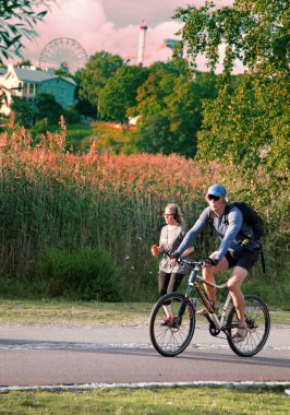 Helsinki, Finlandiya - 22 Ağustos 2017: Bisiklet Park. Bisikletçi doğanın döngüsü lane arka plan üzerinde; kriter yol