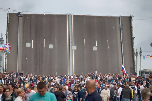 Saint Petersburg, Rusya - 30 Temmuz 2017: Yaz Festivali deniz kuvvetleri. İnsanlar yürüyüş nehir Neva, setin damarları Köprüsü, Denizcilik bayrakları geçiş için boşandı. kablolama Nehri köprüler