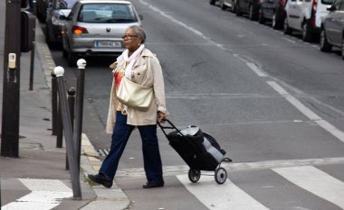 Paris, Fransa - 23 Eylül 2017: saygın yaşlı Asya kadın arabası geçerken sokak ile. Sokak hayatı