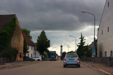 Dillingen, Almanya - 11.09.2017: Küçük özel evler karayolu ve sokak perspektif kilise çan kulesinde boyunca kentin eteklerinde