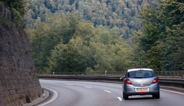 Dillingen, Almanya - 11.09.2017: Keskin dönüşlerle bir dağ serpantin yolda araba. Yol tümsek (tümsek durdurmak) ve duvar taş çöker ve heyelan karşı güçlendirilmiş