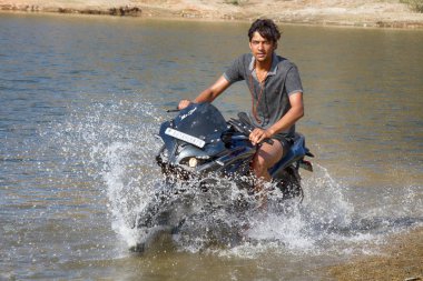 Hindistan, Udaipur - 25 Mart 2018: yüksek hızda bir sprey su genç motosikletçi atılıyor