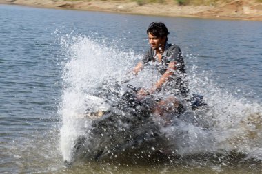 Hindistan, Udaipur - 25 Mart 2018: yüksek hızda bir sprey su genç motosikletçi atılıyor