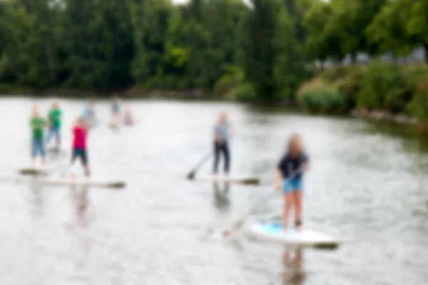 people on a walk on water on paddleboard