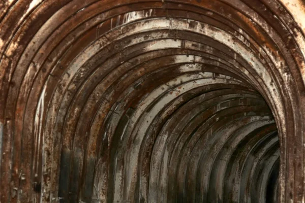 Een oude tunnel met gebogen metalen balken — Stockfoto