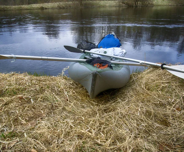 Kayaks moored on shore of pond in grass in spring. — Stock Photo, Image