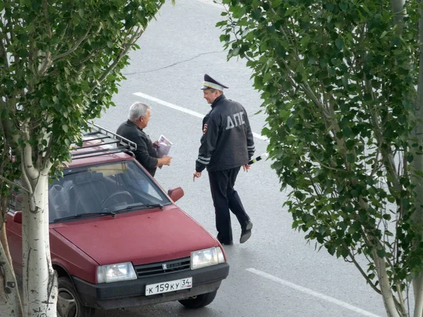 Ryska polisen patrull inspektion checkar förare av bil på gatan — Stockfoto