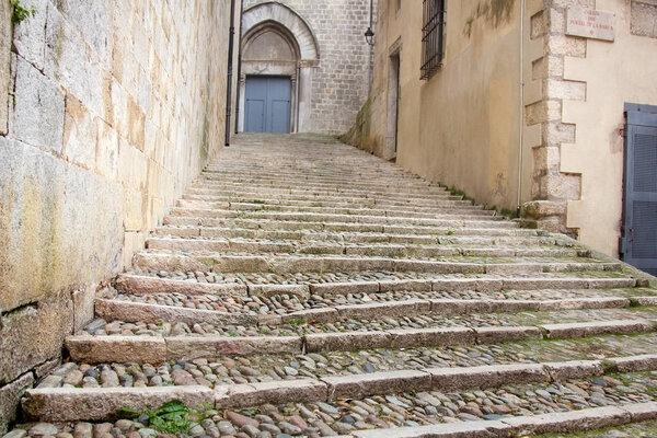 An old cobbled staircase goes up a narrow street, alleyway, cobblestone pavement