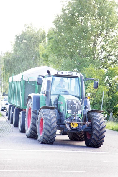 Tractor with a large metal trailer on the road — Stock Photo, Image