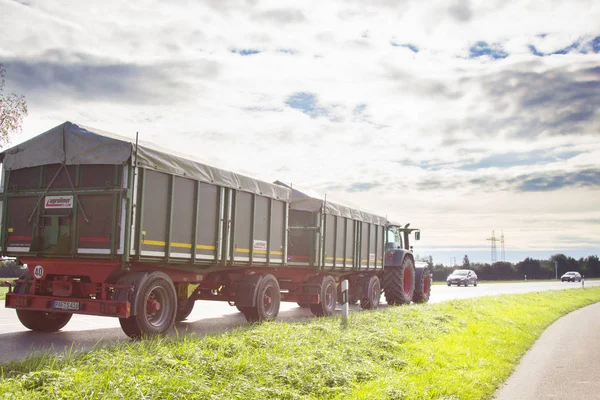 Tractor met een grote metalen aanhangwagen op de weg — Stockfoto