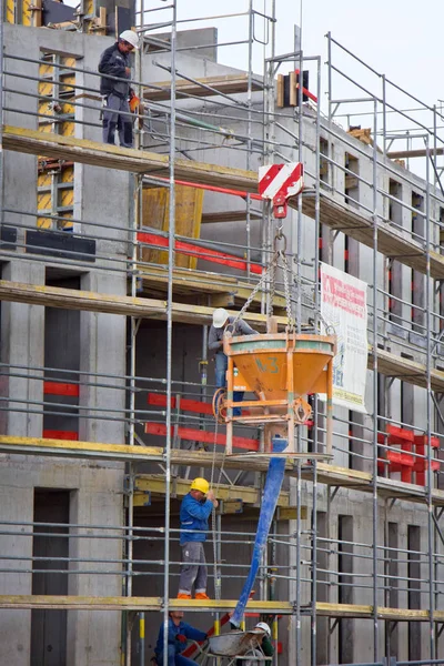 I costruttori sollevano la manica per soluzione in costruzione di case — Foto Stock