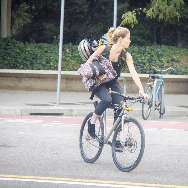 Menina ciclista passeios para fora da cidade com as coisas na mão — Fotografia de Stock