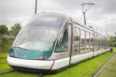 Yolcu elektrikli çevre dostu tramvay taşıma yakın çekim ve yeşil çim ile sokak