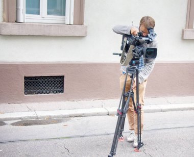 Operatör sokakta bir film kamerasıyla çalışıyor.