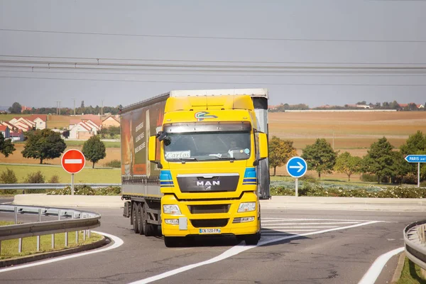 Autostrady i ciężkie ciężarówki na górzystych tle wsi. Przewóz ładunków silnikowych — Zdjęcie stockowe