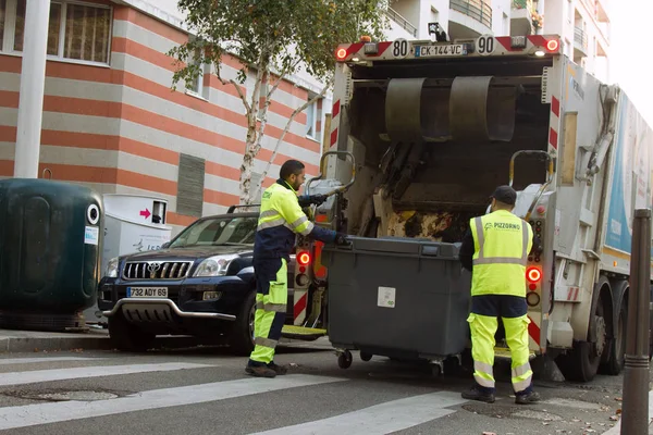 Två vägra samling arbetstagare lastning skräp in i avfall lastbil Tömning behållare — Stockfoto