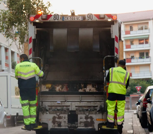 Dos trabajadores de recolección de basura cargando basura en camiones de basura vaciando contenedores — Foto de Stock