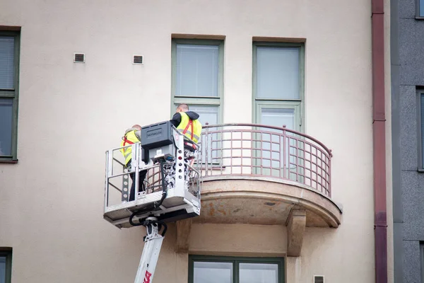 Dwa mycie okien myje balkon, podczas gdy w koszu windy — Zdjęcie stockowe