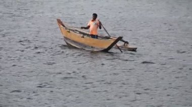 Yerel Seylan erkekleri (sinhalese) oldukça dar bir teknede balık avlıyorlar.