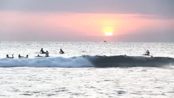 Turis belajar mengendarai sebuah papan (surfing) selama berguling-guling rendah di laut Hindia. — Stok Video