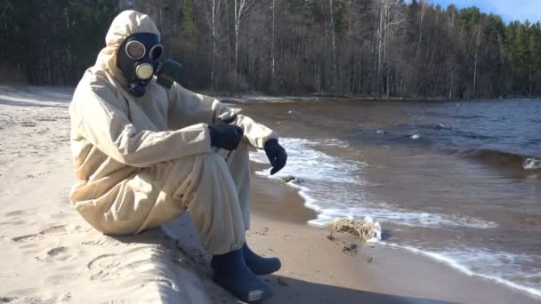 Homme en combinaison de protection, masque sur sable — Video