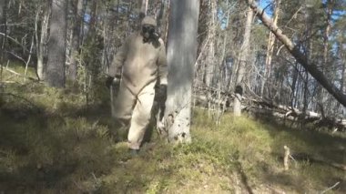Koruyucu giysili adam, ormanda maske.
