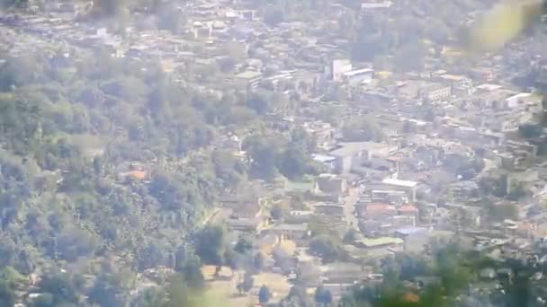Kota di pegunungan ditembak melalui grid dari cabang melambai — Stok Video