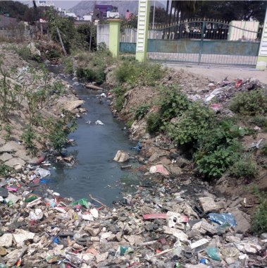 Doğaya plastik bulaşması. Çöp ve şişeler suyun üzerinde yüzüyor. Çevre kirliliği. Nehir suyundaki çöpler.