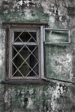 Terk edilmiş evdeki pencere kırılmış. İnsanların olmadığı bir bina.