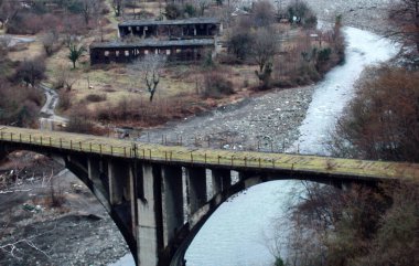 Etkileyici harabeler. Dağ nehri üzerindeki kullanılmayan demiryolu köprüsü, neredeyse yıkılmış bir köprü. Kafkaslar. Abhazya savaşı