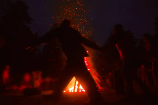 Huge fire at night and young people around. Pagan festival of Walpurgis night: bonfires, dancing wildly, demons, witches. Folk festival, popular holiday. German legends, St. Walburgas, Satanism, devil