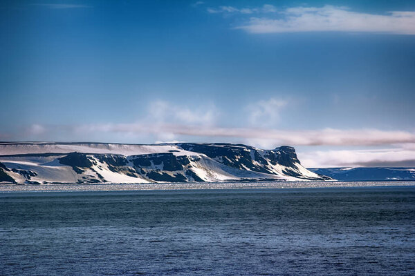 Islands along British channel. Glaciers, icefall, outlet glacier, snowfields, iceberg and rock outcrops. Franz Joseph Land