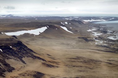 Eski bir buzul çukuru. Çağdaş küçülen buzulun bölgesel ablasyon bölgesi, moraine sınırı (yanal moraine), çürük kayalar. Novaya Zemlya Takımadası. Kuzey Adası. Fotoğraf helikopterden.