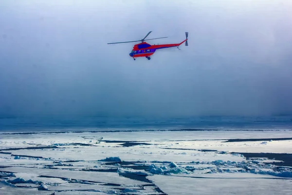 Near the North pole. Ship\'s helicopter Air Service in fog at Arctic ocean (pack ice), air transport in bad weather conditions (utility aviation, leisure aviation)