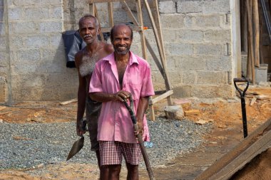 Sri Lanka, Midigama-9 Aralık 2019: Özel bir evin inşaatında mimarların portresi. Harç yapmak için kum kesiyorum.