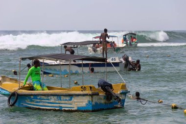 Sri Lanka, Hikkaduwa-11 Aralık 2019: Su bazlı eğlence. Sörf ve resif bölgesindeki sahilde eğlence tekneleri ve tatilciler. Lackadiv Denizi