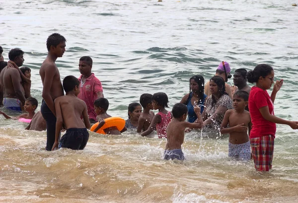 stock image Sri Lanka, Hikkaduwa-December 11, 2019: Sinhalese thrash about in shallow water on day off. Women do not take off their outer clothing because of traditional decency. Laccadive Sea