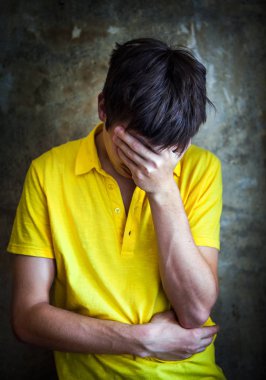 Üzgün genç adam tarafından duvar eski fotoğraf vinyet etkisi