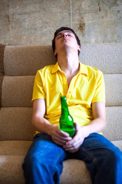 Tired Young Man Bottle Beer Sofa Old Wall — Stock Photo, Image