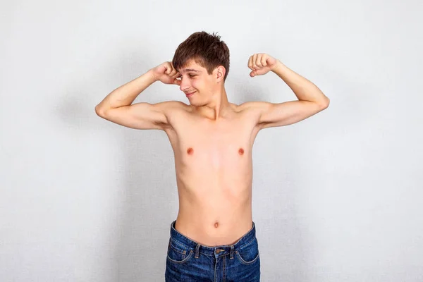 細い若い男白い壁バック グラウンド上の筋肉の屈曲 — ストック写真
