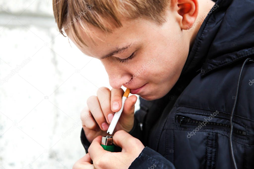 Kid smoke a Cigarette on the Street closeup