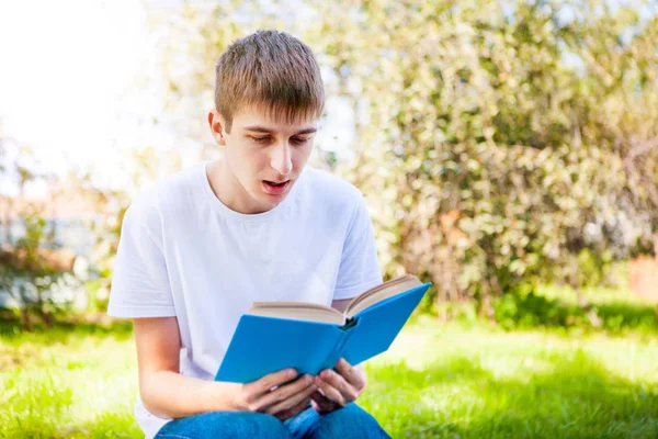 夏の公園で本を読む若い男 — ストック写真