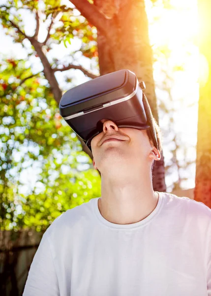 Young Man in Virtual Reality Glasses on the Nature Background